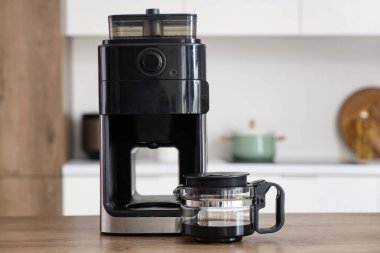 Modern kahve makinesi mutfaktaki ahşap masada.