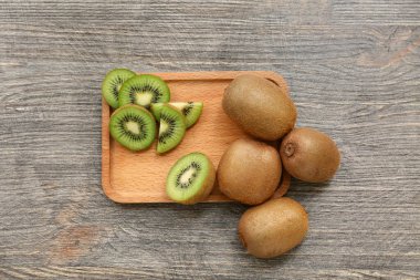 Gri ahşap arka planda taze kivi olan tahta.