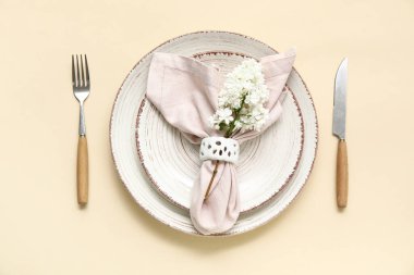 Bej arkaplanda leylak çiçekleri olan güzel bir masa.