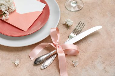 Leylak çiçekleri ve bej arkaplanlı zarf ile güzel bir masa.