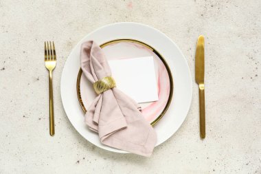 Beyaz arka planda altın çatal bıçak seti olan güzel bir masa.