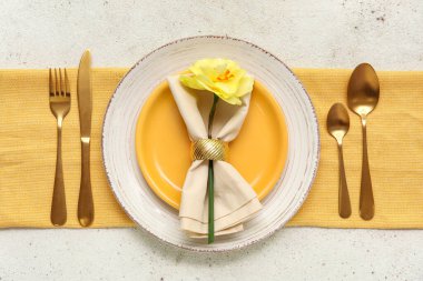 Altın çatal bıçaklı şık masa ve beyaz arka planda güzel bir çiçek.
