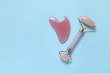 Mavi arka planda Jade roller ve gua sha