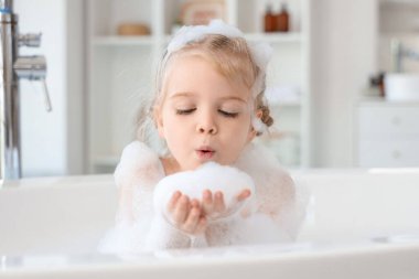 Köpüklü şirin kız banyoda banyo yapıyor.