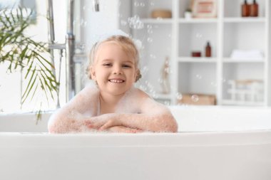 Köpüklü, köpüklü, banyoda banyo yapan tatlı küçük kız.