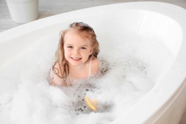 Köpüklü şirin kız banyoda banyo yapıyor.