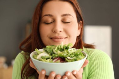 Evde taze sebze salatalı hamile bir kadın, yakın plan.