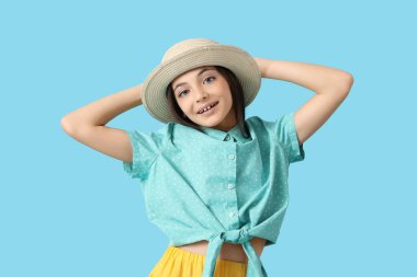 Mavi arka planda şapkalı şirin bir turist.