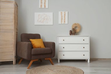 Tabloları, koltuğu ve tuvaleti olan şık bir oturma odası.