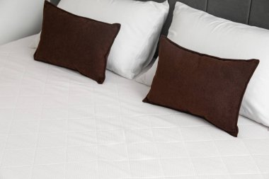 Yastıklı yeni ortopedik yatak. Odada şık bir yatak, yakın plan.