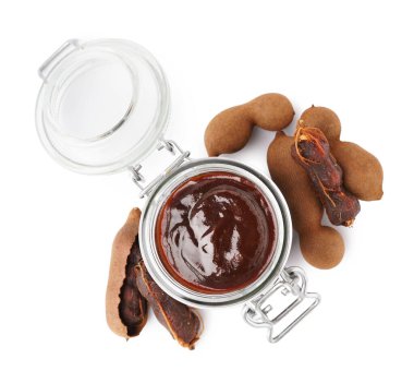 Jar with tasty tamarind jam with fruits on white background