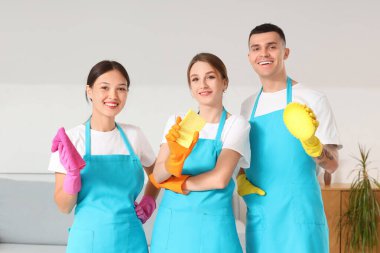 Odada temizlik malzemeleri olan bir grup genç hademe.