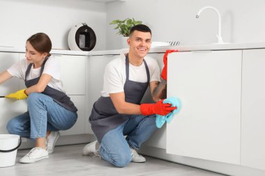 Erkek hademe mutfak çekmecesini temizliyor.