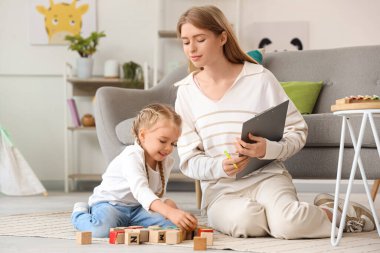 Psikologların ofisinde küplerle oynayan küçük bir kız.