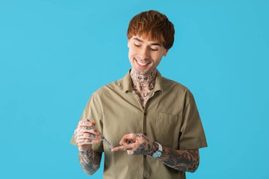 Mavi arka planda tükenmez kalem kullanan diyabetik genç adam.