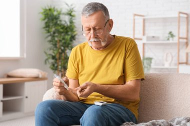 Yaşlı adam evde kendine insülin iğnesi yapıyor. Diyabet kavramı