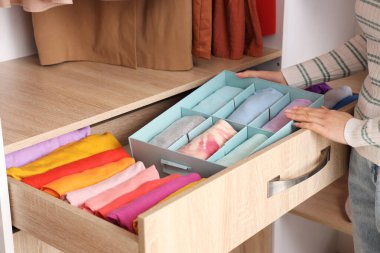 Evde temiz elbiseli bir kadın var.