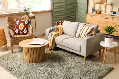 Işıl ışıl oturma odasının içinde rahat bir kanepe ve sehpa var.