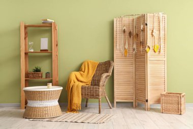 Rahat koltuğu, sehpası ve katlanabilir ekranı olan şık bir oda.