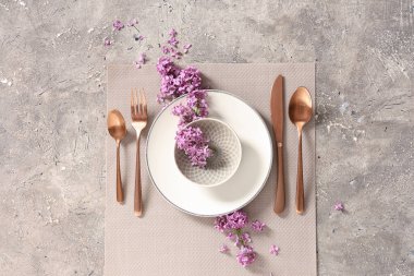Gri grunge arka planında leylak çiçekleri olan güzel bir masa.