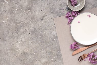 Gri grunge arka planında leylak çiçekleri olan güzel bir masa.