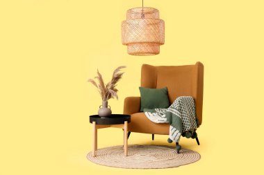 Sarı arka planda ekose ve minderli rahat koltuk