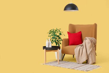 Sarı arka planda ekose ve minderli rahat koltuk