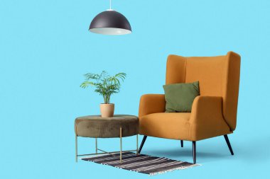 Mavi arka planda bitkileri olan yastıklı rahat bir koltuk.