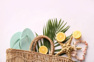Beyaz arka planda şık plaj aksesuarları, palmiye yaprağı ve limonları olan kompozisyon