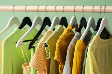 Askıda asılı kadın giysileri yeşil arka planda