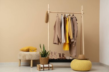 Bej duvarın yanında kadın giysileriyle dizilin.