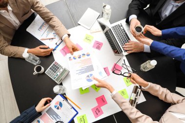 Yapışkan notları olan iş adamları siyah masa, üst görünüm de çalışıyorlar.