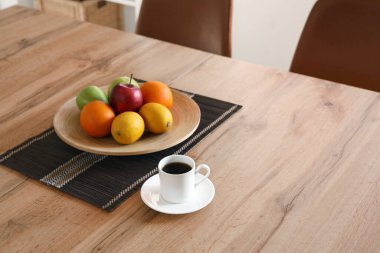 Yemek masasında kahve fincanı olan meyveler, yakın plan.