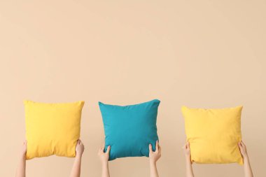 Bej arka planda parlak yastıklı kadınlar