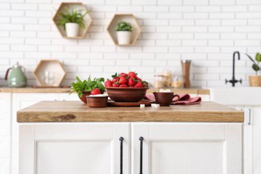 Mutfaktaki masada lezzetli çilek, şeker ve nane şekerli kaseler.