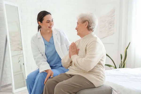 stock image Physical therapist with senior woman sitting in bedroom