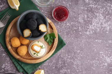 Değişik kızarmış mozzarella topları ve grunge arkaplanda sosları olan ahşap tahta bir tahta tahta tahta.