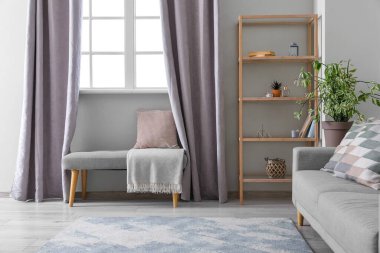 Yumuşak bank ve raf ünitesi olan modern oturma odası.