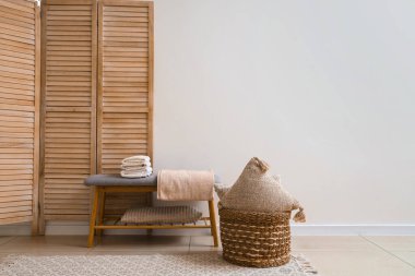 Beyaz duvarın yanındaki yumuşak bankta yığınla temiz yumuşak havlu.