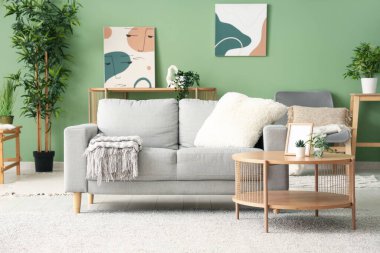 Renk duvarına yakın masa ve kanepesi olan modern oturma odasının içinde.