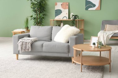 Renk duvarına yakın masa ve kanepesi olan modern oturma odasının içinde.