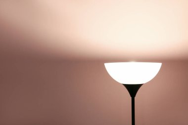 Pembe arka planda parlayan yer lambası, yakın plan