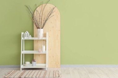 Odanın içinde ahşap tahta ve vazoda söğüt dalları var.