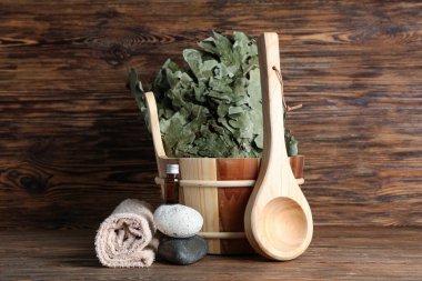 Ahşap arka planda sauna için farklı aksesuarlar.