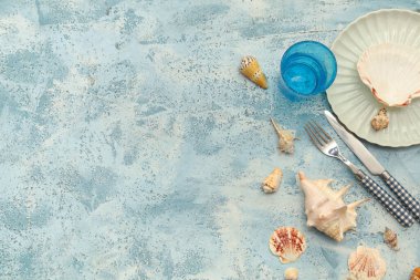 Mavi grunge arka planında deniz kabukları olan güzel masa ayarları