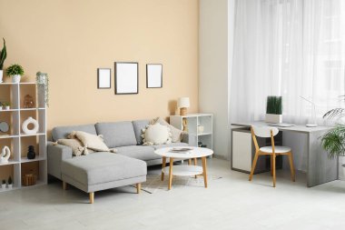 Rahat kanepesi, sehpası, işyeri ve perdesi olan şık bir oturma odası.