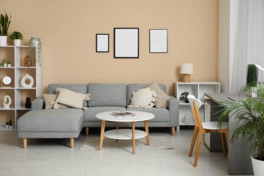 Rahat kanepesi, sehpası, işyeri ve perdesi olan şık bir oturma odası.