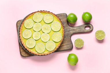 Ahşap tahta, pembe arka planda lezzetli limonlu tart.