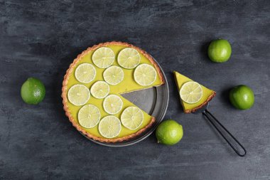 Siyah arka planda lezzetli limonlu turta ve spatula.
