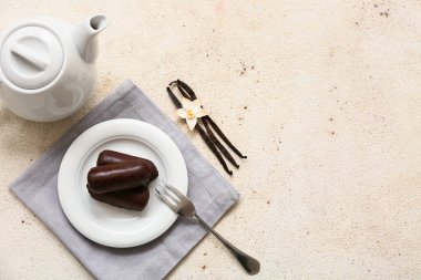 Beyaz grunge arka planda vanilyalı lezzetli süzme peynirli çay demliği ve tabak.